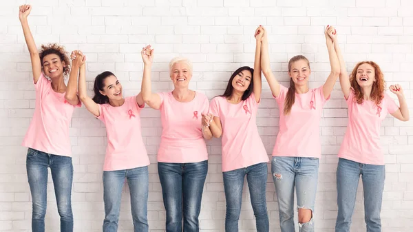 Grupo de Apoyo al Cáncer de Mama Sostiene Manos Levantadas Sobre la Pared Blanca — Foto de Stock