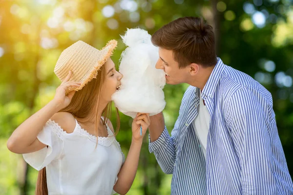 可愛いです女の子とともに彼女のボーイフレンド食べる綿キャンディー一緒に公園で — ストック写真