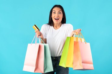 Alışveriş torbaları ve plastik kartlarla aşırı neşeli bir kadın.