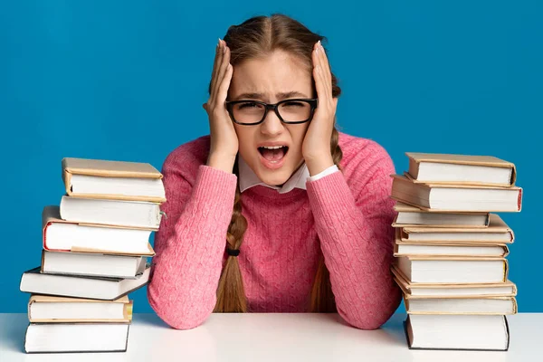 Ragazza urlando e tenendo la testa, vicino a un sacco di libri — Foto Stock