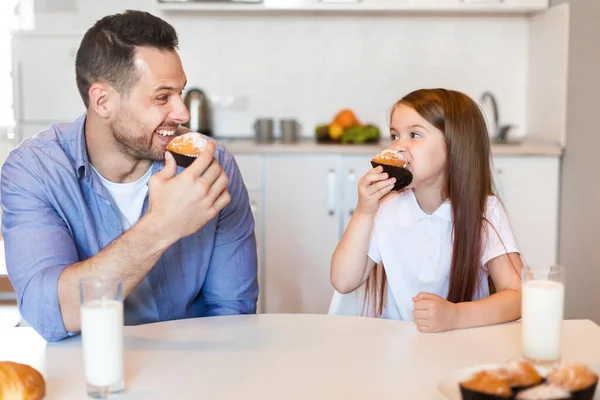 Malá dívka a její otec jí muffiny v kuchyni uvnitř — Stock fotografie