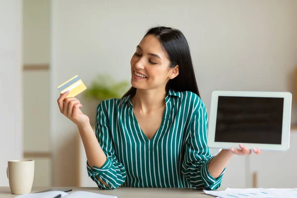Affärskvinna innehar kreditkort Visar surfplatta Skärm sitter i Office — Stockfoto