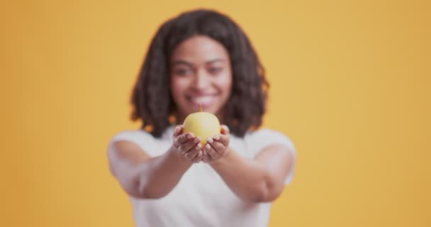 Färskt grönt äpple i händerna på vänlig afrikansk amerikansk flicka — Stockvideo