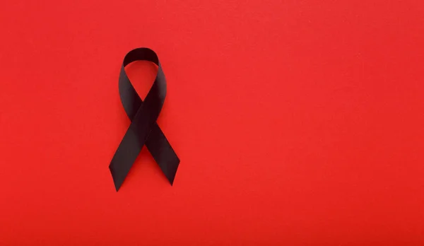 AIDS Black Awareness Realistic Ribbon isolated on red — 图库照片
