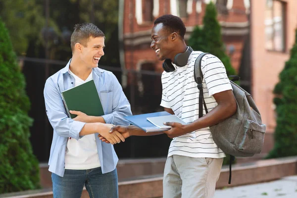 Zwei multiethnische College-Freunde entspannen sich nach dem Unterricht im Freien — Stockfoto