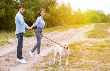 Tatlı bir çift ve kırsalda yürüyen bir av köpeği.