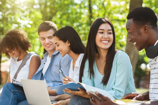 Vrolijke universitaire vrienden rusten tussen de klassen buiten, kletsen en lachen — Stockfoto