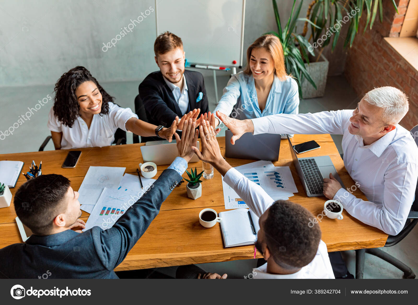 Colleagues Giving High-Five Celebrating Business Success Standing In Office  Stock Photo by ©Milkos 381522740