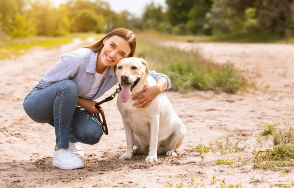 Spännande kvinna och golden retriever gå utomhus — Stockfoto