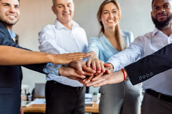 Compañeros de trabajo sosteniendo las manos celebrando el éxito empresarial en la oficina moderna, recortado — Foto de Stock