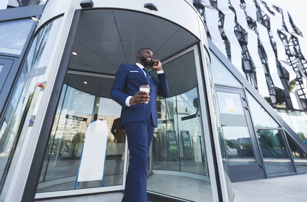 Happy African Businessman Talking On Cellphone Leaving Business Center, Low-Angle — стокове фото