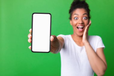 Stüdyoda beyaz boş cep telefonu ekranı gösteren bir kız