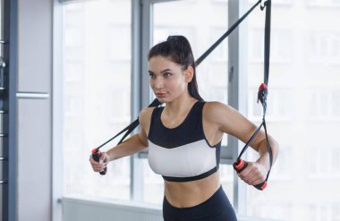 Kablo TV 'de çalışan, spor salonunda ağırlık kaldıran güçlü bir kız.