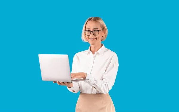 Online práce. Úspěšný pracovník kanceláře držící notebook na modrém pozadí — Stock fotografie