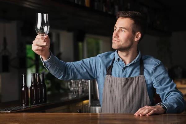 Prêt à recevoir des clients. Barman vérifie la qualité de pur de verre vide — Photo