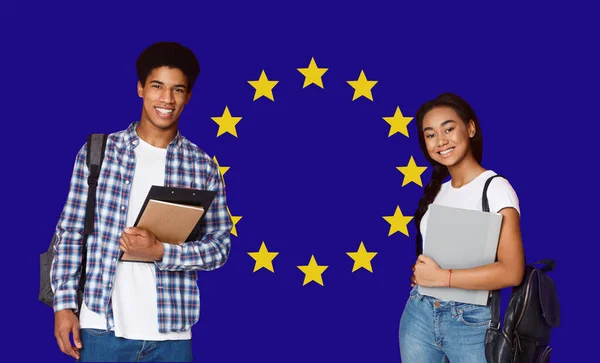 Study In Europe. Black Teen Guy And Girl Posing Over EU Flag