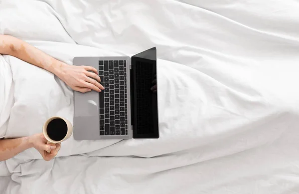 Mujer usando portátil con pantalla en blanco en la cama por la mañana — Foto de Stock