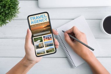 Açık Çevrimiçi Seyahat Ajansı Uygulaması ve Notları Olan Akıllı Telefonu Tutan Kadın