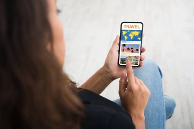 Açık seyahat sitesi olan akıllı telefon kullanan tanınmayan bir kadın