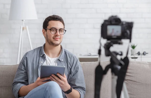 Vlog para seguidores. Chico con la tableta en las manos mira a la cámara y graba vídeo — Foto de Stock