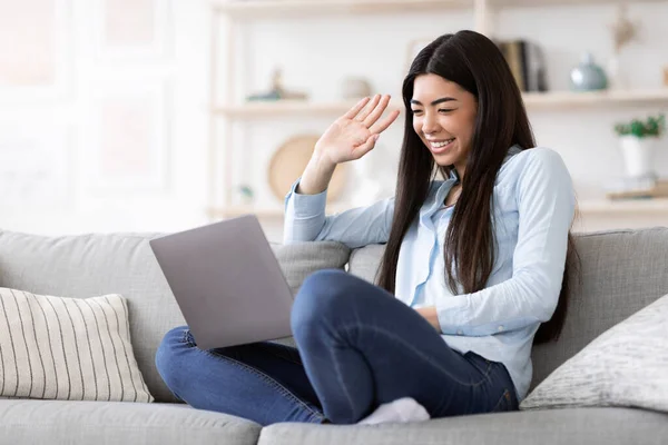 陽気なアジアの女の子作るビデオ電話上のノートパソコンで自宅、手を振って画面 — ストック写真