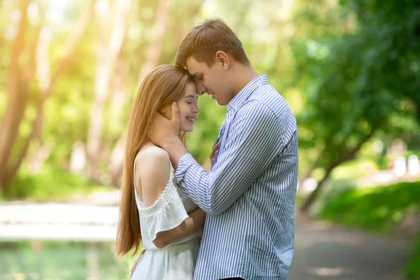Felice giovane coppia che abbraccia su appuntamento romantico al parco — Foto Stock