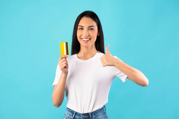 Chica sosteniendo tarjeta de crédito y mostrando el pulgar hacia arriba — Foto de Stock