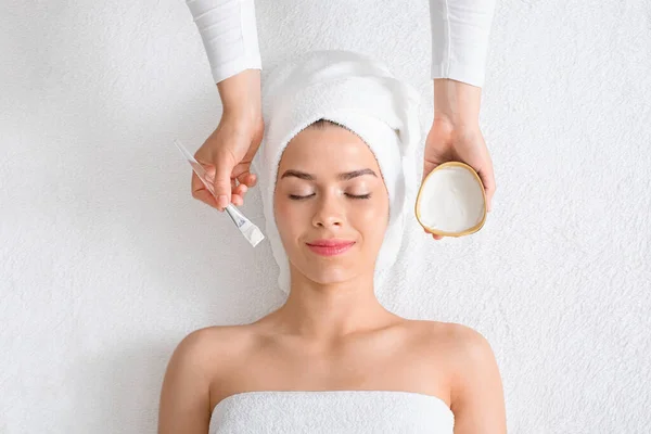 Widok z góry kosmetologa stosującego maskę oczyszczającą na twarz kobiety — Zdjęcie stockowe