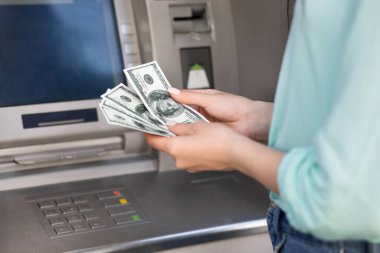 Tanınmayan Kadın ATM 'nin yanında Para Sayıyor