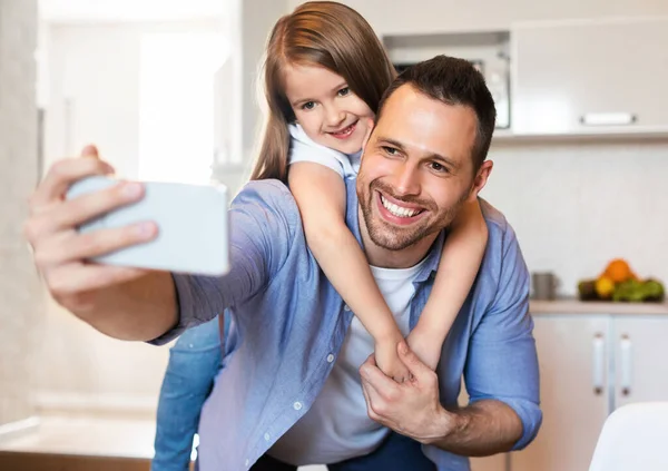 Alegre pai e filha fazendo selfie se divertindo na cozinha — Fotografia de Stock
