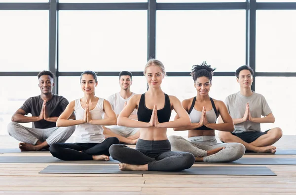 Namaste. Unga sportiga människor utövar yoga i modern idrottsklubb — Stockfoto