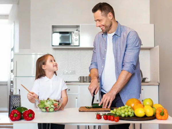 陽気お父さんと娘が一緒にキッチンでサラダを作る — ストック写真