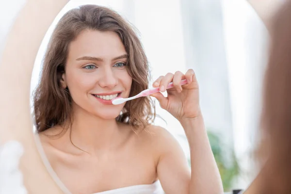 Jovem mulher escovando os dentes no banheiro em casa — Fotografia de Stock