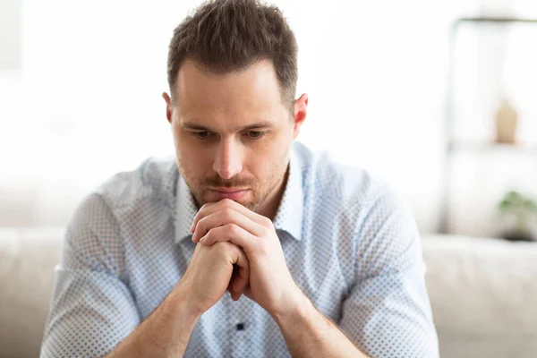 Ragazzo pensieroso seduto sul divano, guardando giù — Foto Stock