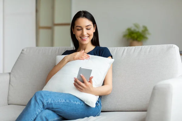 Chica alegre usando el teléfono celular Navegación por Internet Sentado en casa — Foto de Stock