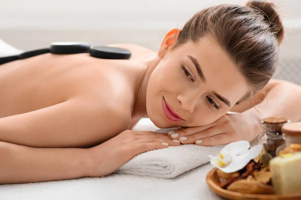 Close-up de mulher pacífica desfrutando de pedras quentes massagem e aromaterapia — Fotografia de Stock