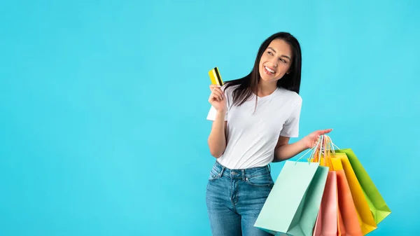 Leende kvinna med shoppingväskor och plastkort — Stockfoto