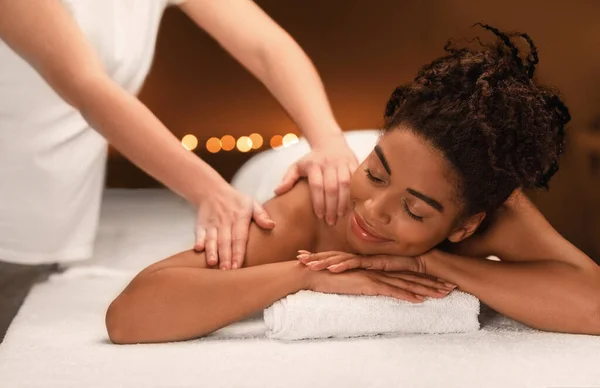 Ung svart kvinna får massage på spa — Stockfoto