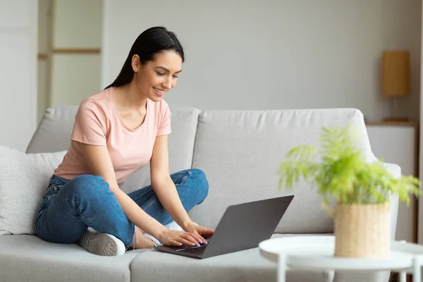 Ragazza freelancer di successo utilizzando computer portatile seduto sul divano all'aperto — Foto Stock