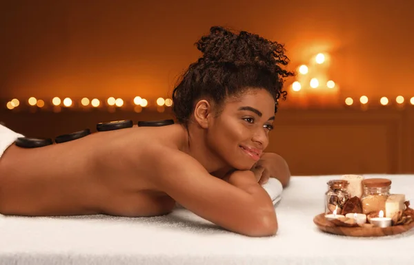 Mulher africana pacífica desfrutando de massagem de cura no spa — Fotografia de Stock