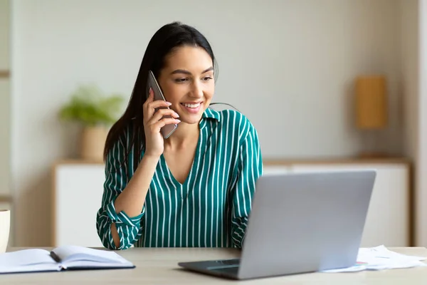 Gelukkig vrouwelijk ondernemer praten op mobiele telefoon in modern kantoor — Stockfoto