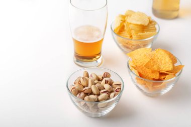 Bira çerezi. Bardakta parlak biralar, fıstıklar, cipsler.