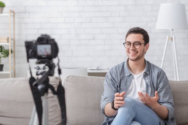 Pazarlama, e-ticaret ve video blogları. Gülümseyen adam kamerayla video çekiyor.