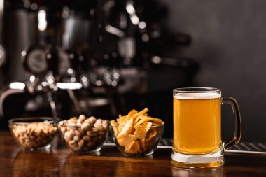 El yapımı bira festivali. Fıstıklar, cipsler ve fındıklar cam tabaklarda ve biralar da iç mekanda.