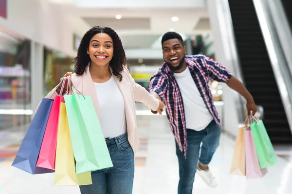 Försäljningssäsong. Spännande svart kvinna dra pojkvän att handla butik — Stockfoto