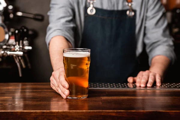 Pub favorit. Bartender memberikan bir di meja di interior pub — Stok Foto