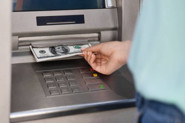Tanınmayan bir kadın ATM 'den nakit para alıyor. Kesilmiş bir görüntü.