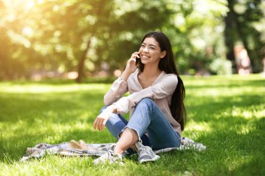 Park 'ta cep telefonuyla konuşan Asyalı kız.