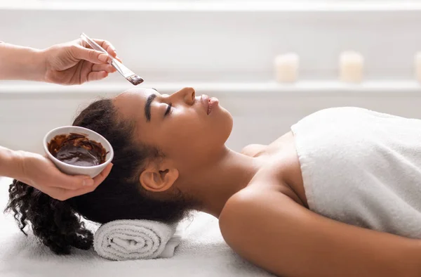 Mujer negra recibiendo tratamiento facial en spa de lujo —  Fotos de Stock