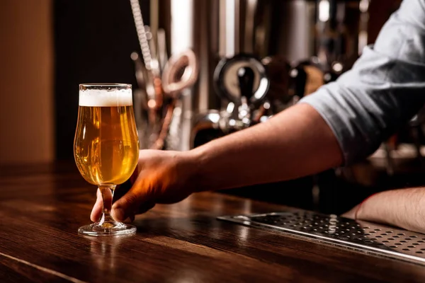 Bebidas, diversão, reunião, Oktoberfest. Barman serve cerveja no balcão no interior do pub — Fotografia de Stock